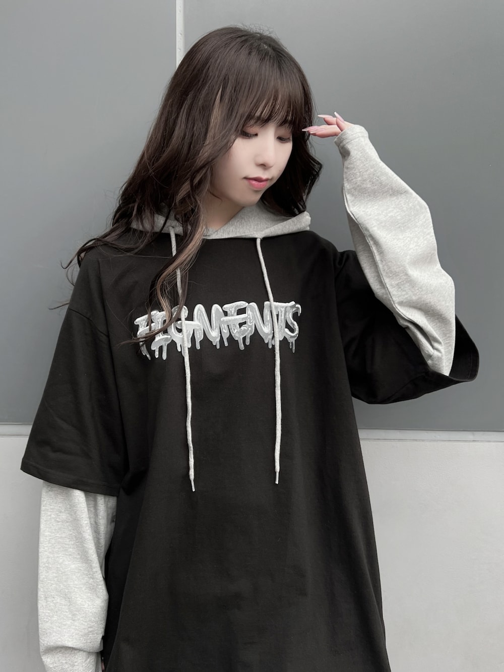 グレー系のTシャツ/カットソー、ブラック系のスカート、ブラック系のスニーカーを着用したレディースの春コーディネートの2枚目の写真