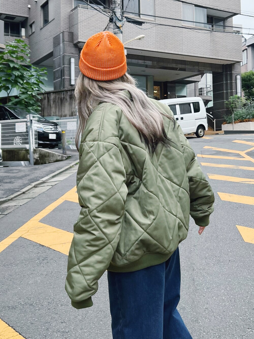 グリーン系のミリタリージャケット、ブルー系のデニムパンツ、グレー系のスウェットを着用したレディースの冬コーディネートの2枚目の写真