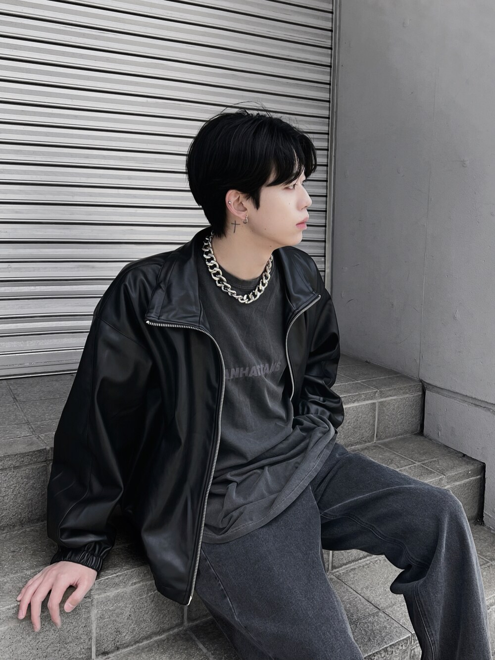 ブラック系のデニムパンツ、ブラック系のブルゾン、グレー系のTシャツ/カットソーを着用したメンズの春コーディネートの2枚目の写真