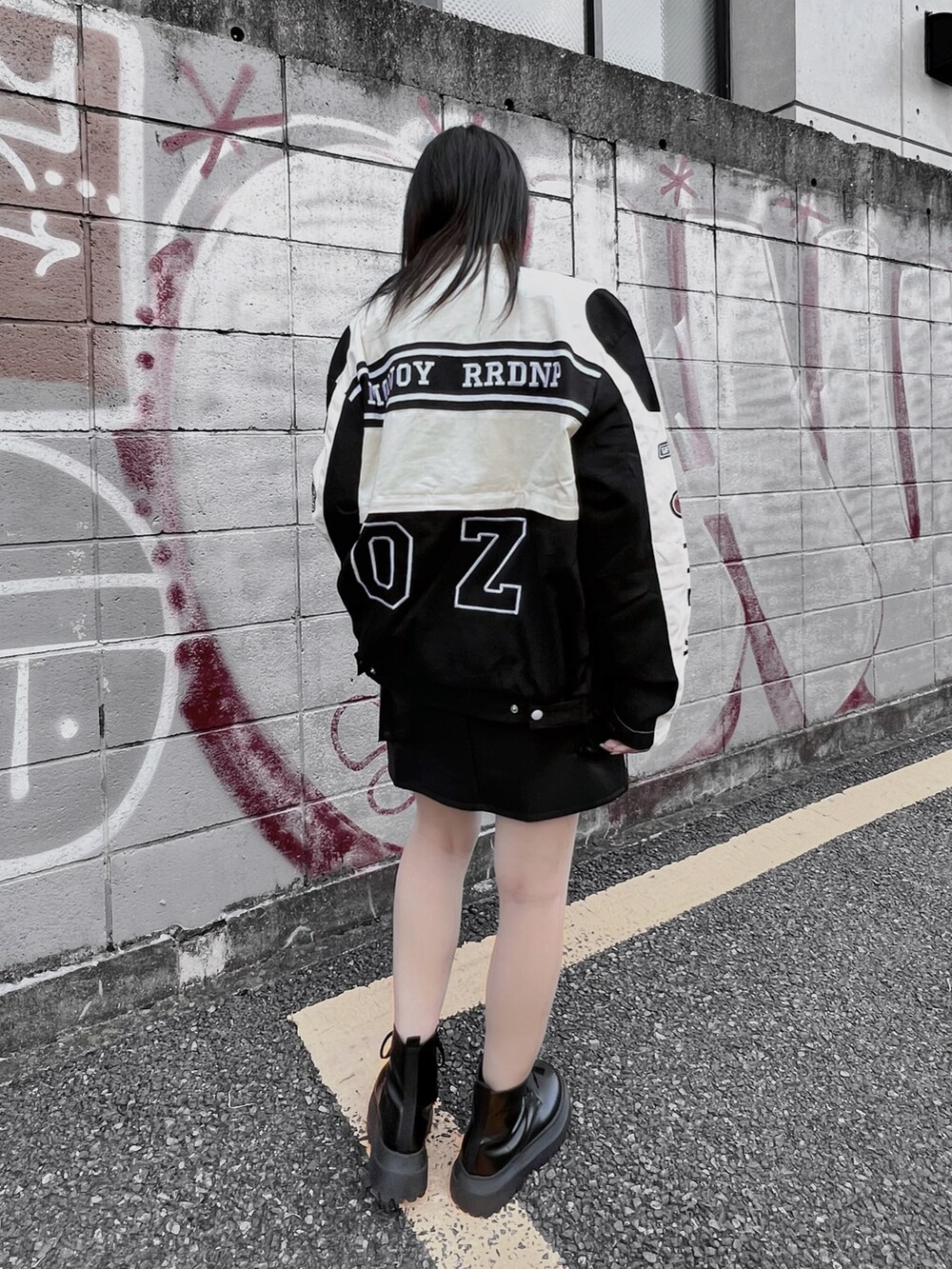 ホワイト系のTシャツ/カットソー、ブラック系のブーツ、ブラック系のブルゾンを着用したレディースの秋コーディネートの5枚目の写真