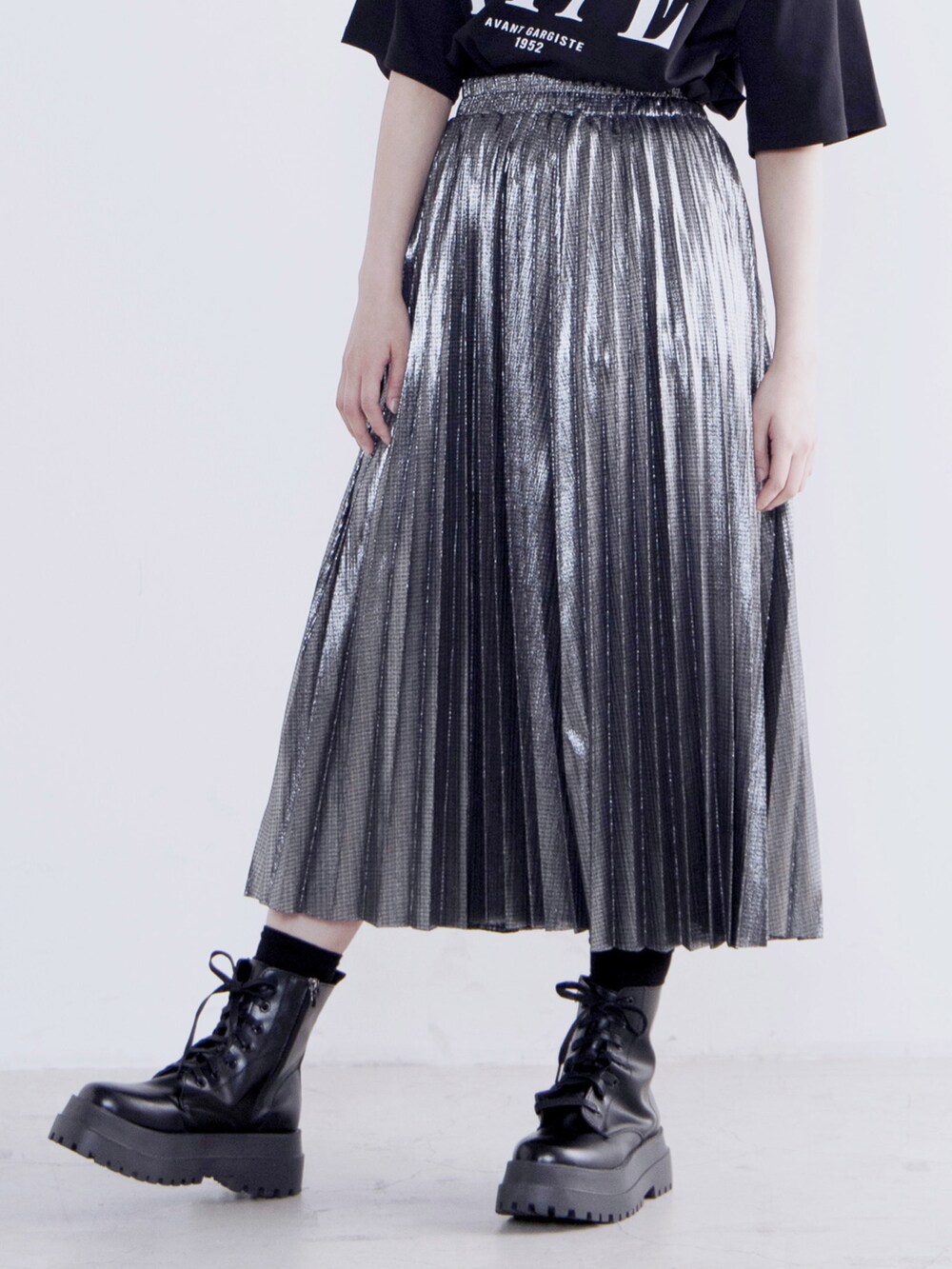 ブラック系のTシャツ/カットソー、シルバー系のスカート、ブラック系のブーツを着用したレディースの夏コーディネートの3枚目の写真