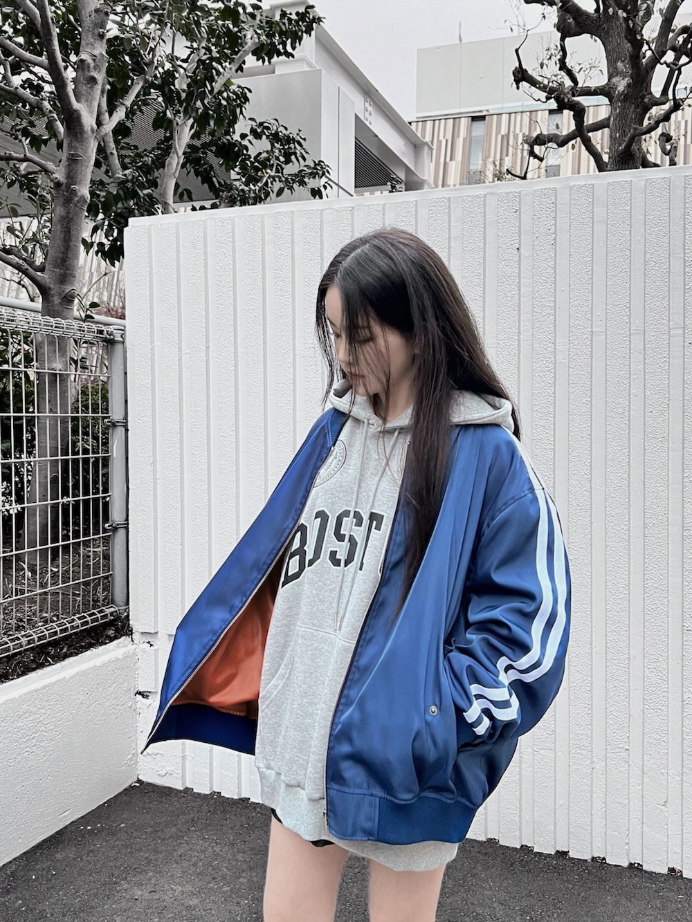 グレー系のパーカー、ブルー系のブルゾンを着用したレディースの冬コーディネートの3枚目の写真