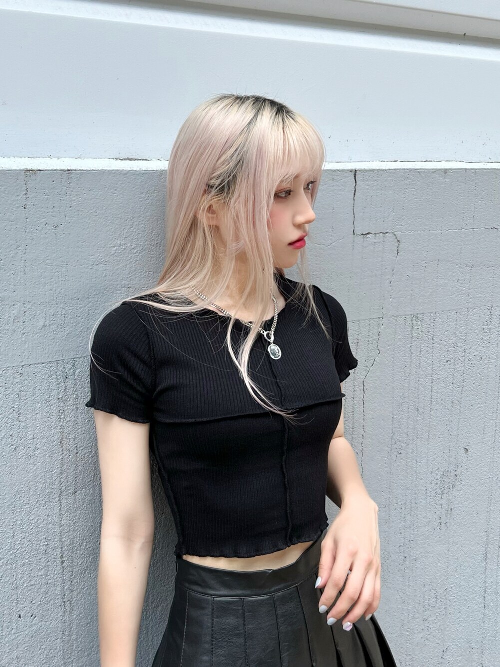 ブラック系のスカート、ブラック系のTシャツ/カットソー、ブラック系のブーツを着用したレディースの秋コーディネートの3枚目の写真