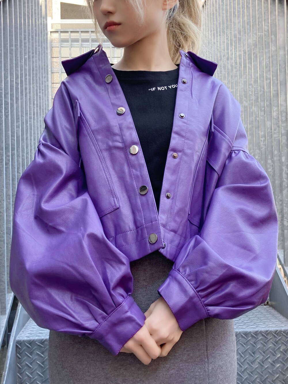 ブラック系のTシャツ/カットソー、パープル系のライダースジャケット、グレー系のスカートを着用したレディースの冬コーディネートの2枚目の写真