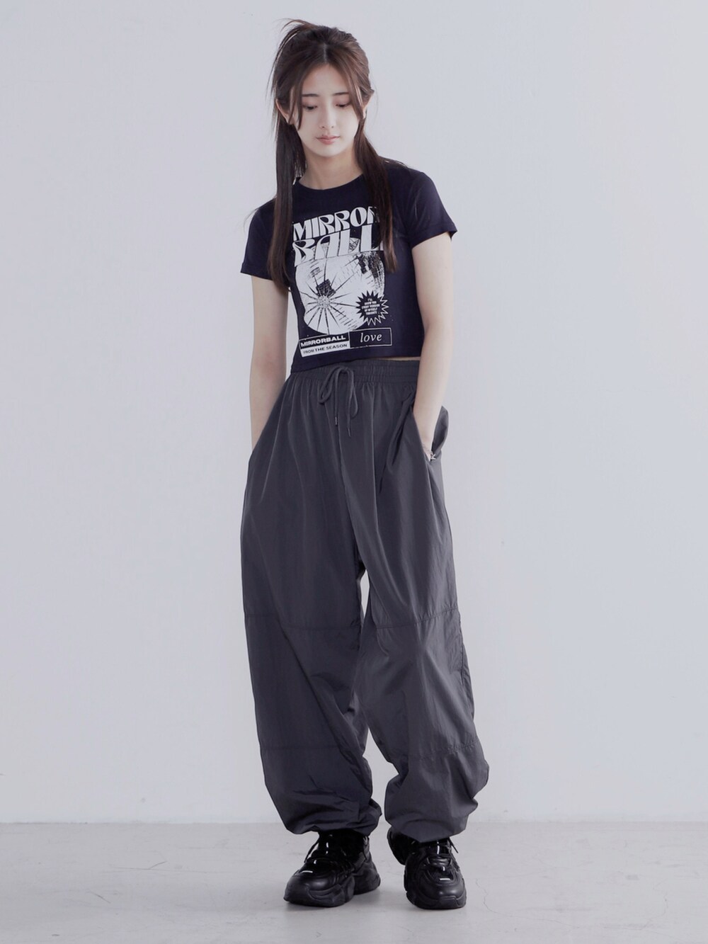 ブラック系のショルダーバッグ、ブラック系のその他パンツ、ブラック系のスニーカーを着用したレディースの夏コーディネートの2枚目の写真