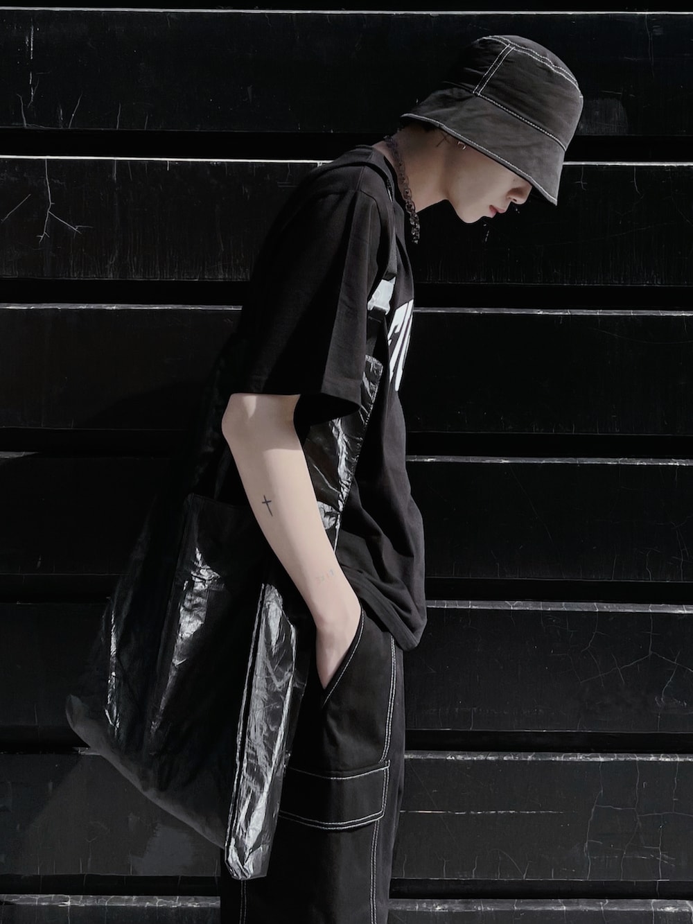 ブラック系のTシャツ/カットソー、ブラック系のトートバッグ、ホワイト系のスニーカーを着用したメンズの春コーディネートの3枚目の写真