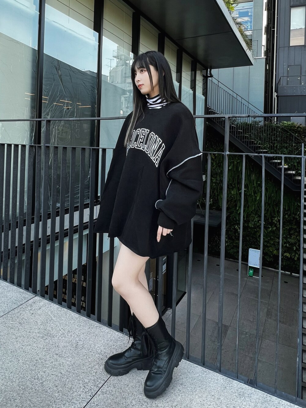 ブラック系のスウェット、ブラック系のブーツ、ホワイト系のTシャツ/カットソーを着用したレディースの冬コーディネートの3枚目の写真