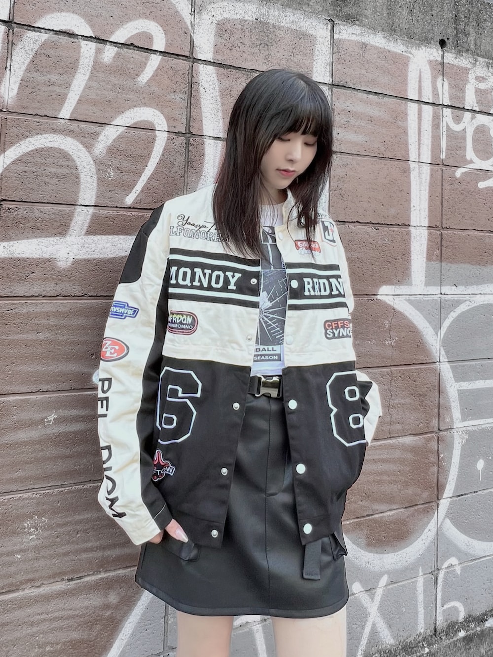 ホワイト系のTシャツ/カットソー、ブラック系のブーツ、ブラック系のブルゾンを着用したレディースの秋コーディネートの2枚目の写真