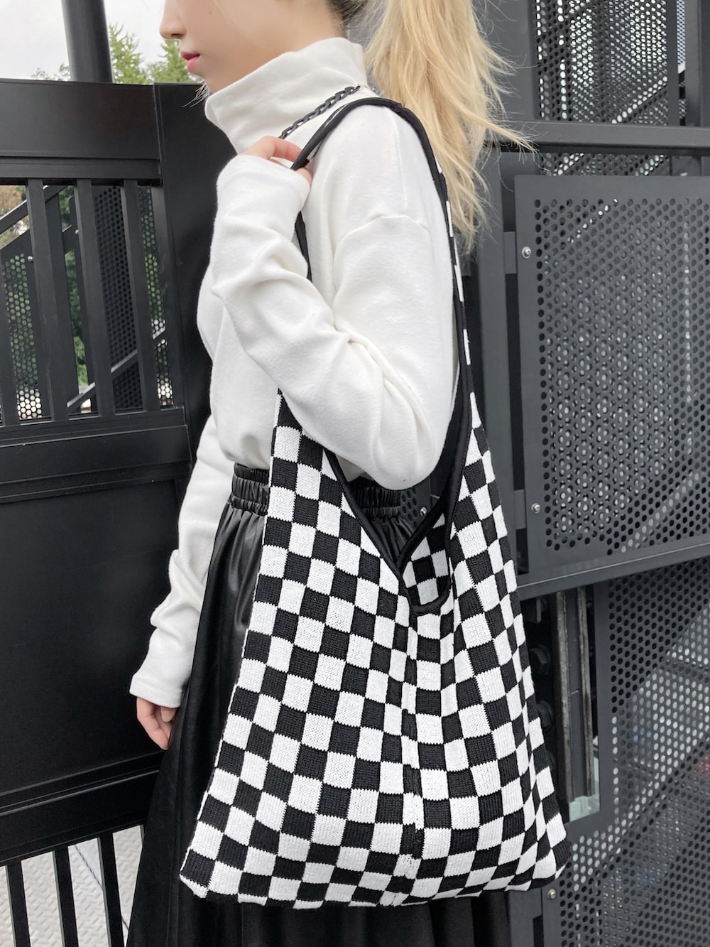 ホワイト系のTシャツ/カットソー、ブラック系のスカート、ブラック系のブーツを着用したレディースの冬コーディネートの2枚目の写真