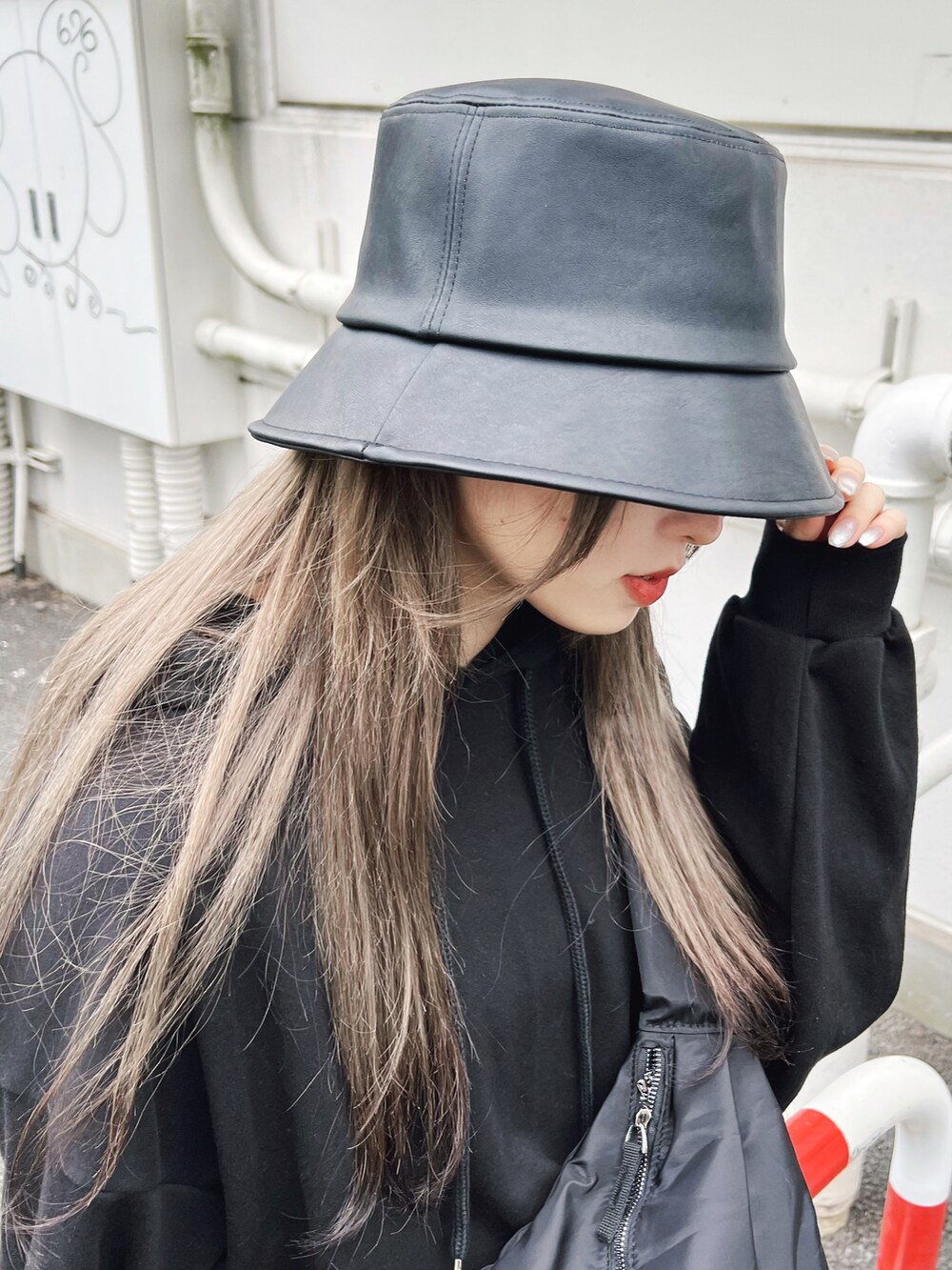 ブラック系のパーカー、ブルー系のその他パンツ、ブラック系のハットを着用したレディースの冬コーディネートの4枚目の写真