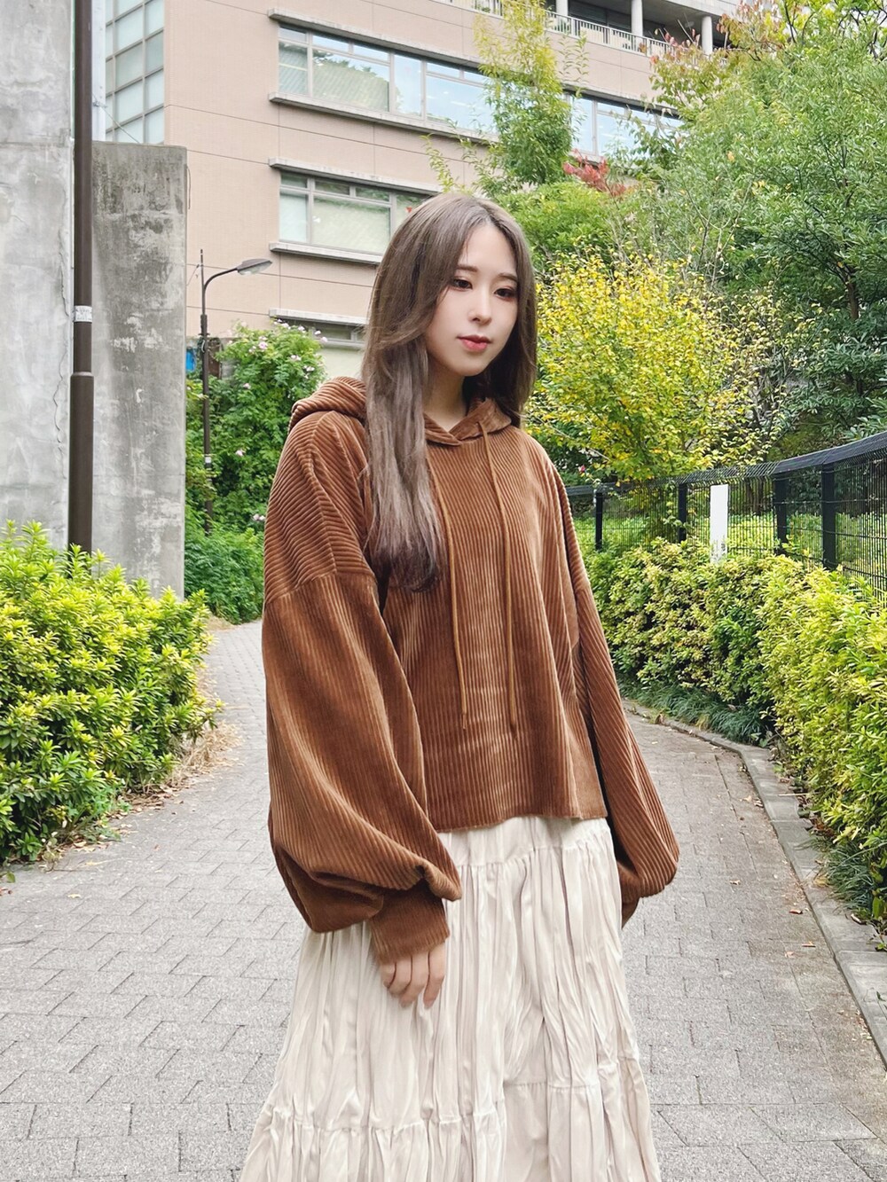 ブラウン系のパーカー、ホワイト系のスカート、ホワイト系のブーツを着用したレディースの冬コーディネートの3枚目の写真