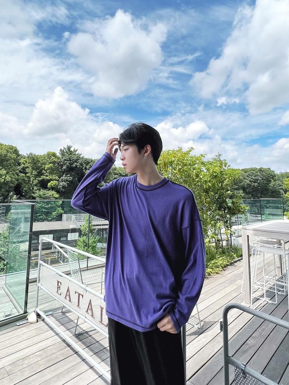 ブラック系のダウンベスト、パープル系のTシャツ/カットソー、ブラック系のデニムパンツを着用したメンズの秋コーディネートの3枚目の写真