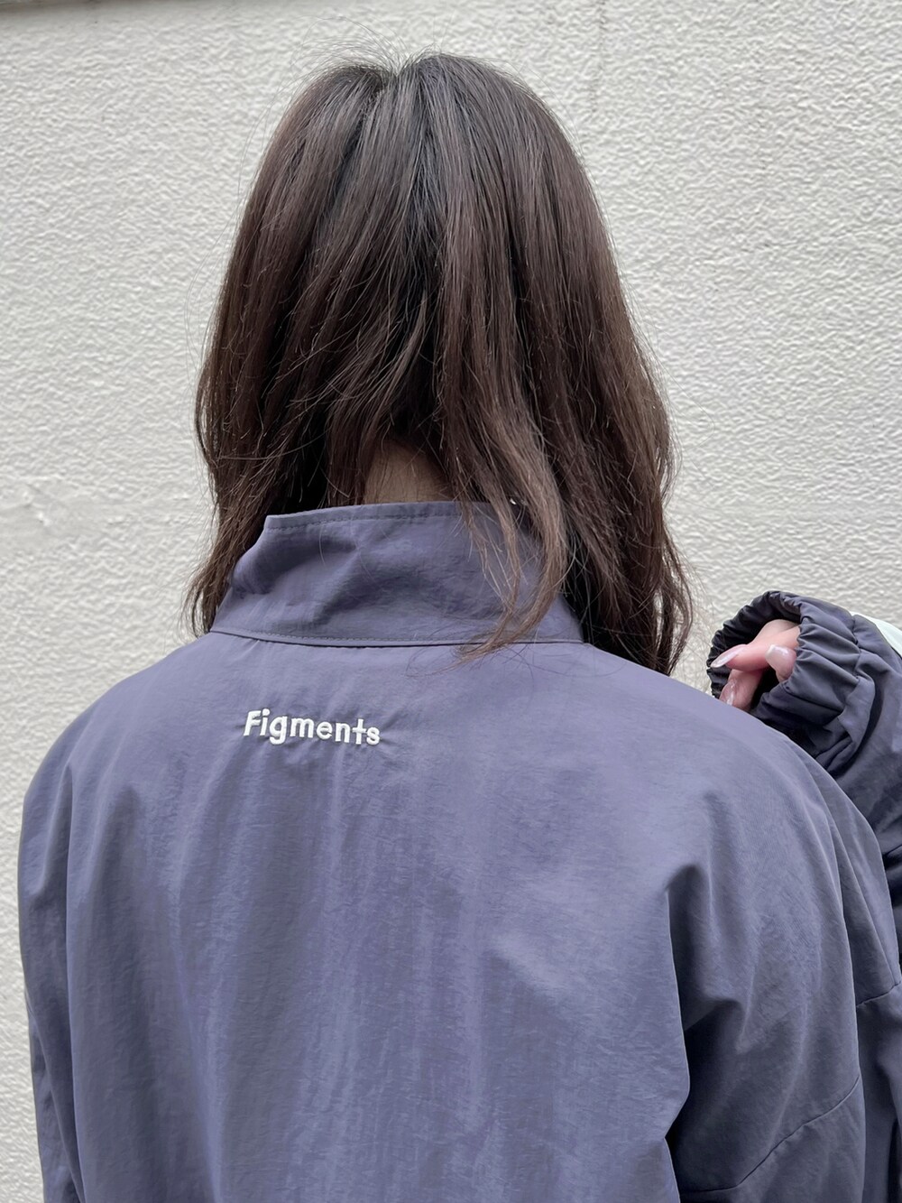 ホワイト系のスニーカー、パープル系のナイロンジャケット、パープル系のその他パンツを着用したレディースの冬コーディネートの3枚目の写真