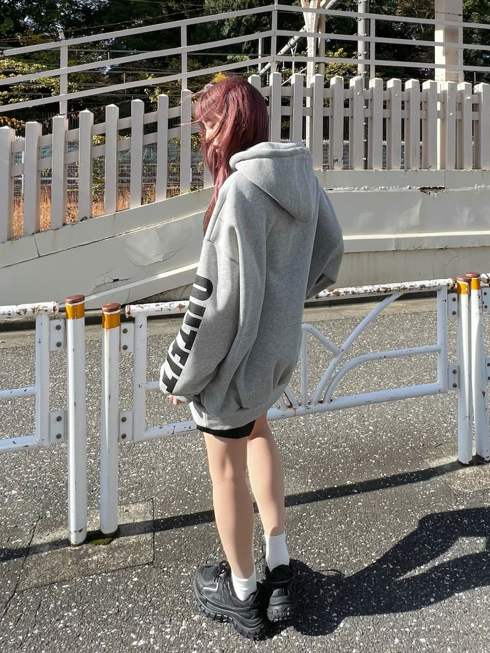 ブラック系のスニーカー、ブラック系のスカート、グレー系のパーカーを着用したレディースの冬コーディネートの3枚目の写真