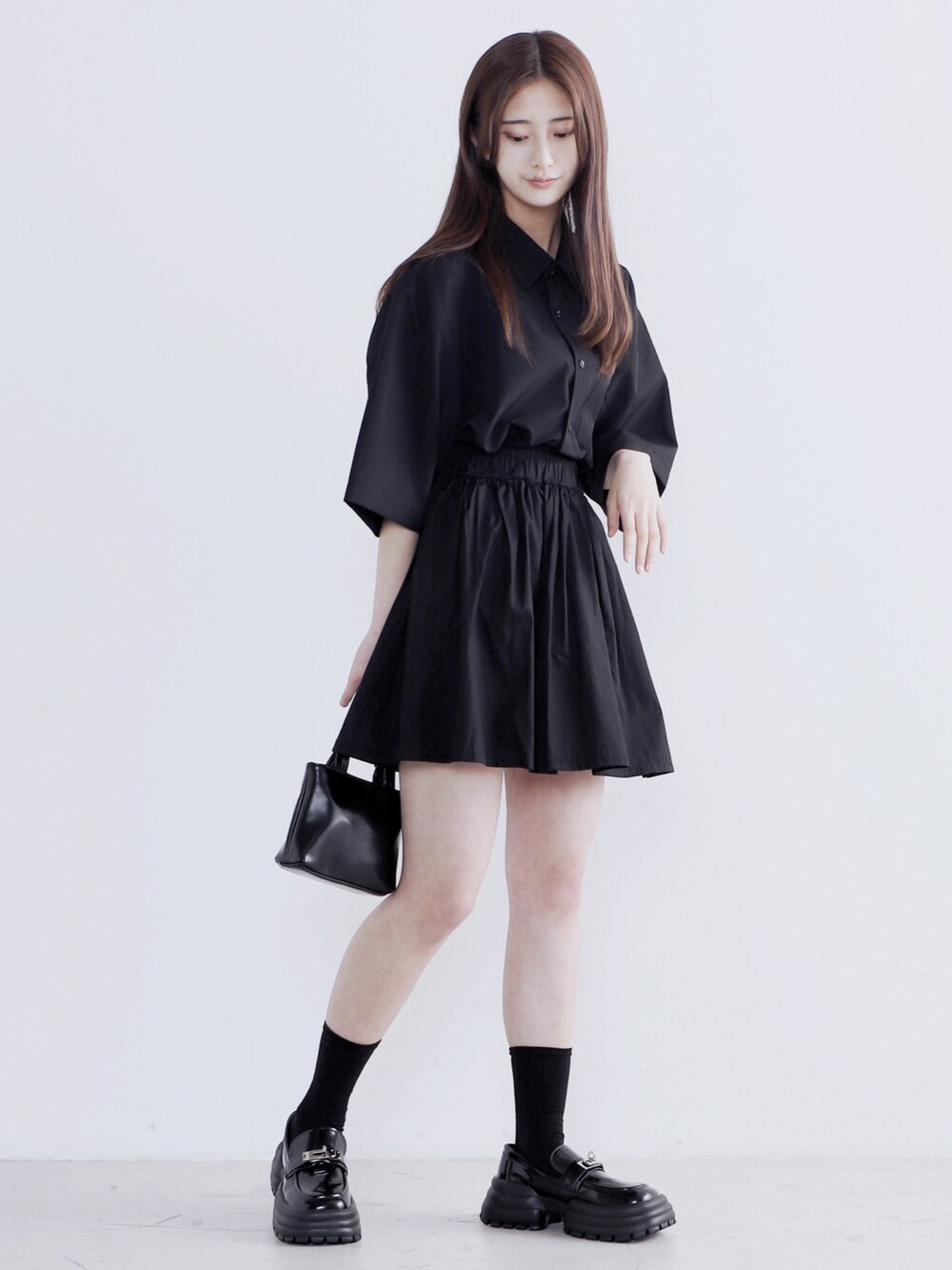 ブラック系のドレスシューズ、ブラック系のショルダーバッグ、ブラック系のシャツ/ブラウスを着用したレディースの春コーディネートの2枚目の写真