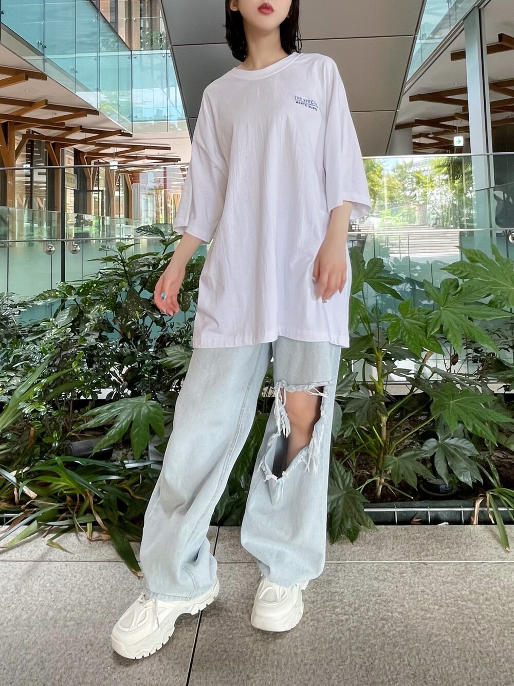 ブルー系のデニムパンツ、ホワイト系のスニーカー、ホワイト系のTシャツ/カットソーを着用したレディースの夏コーディネートの3枚目の写真