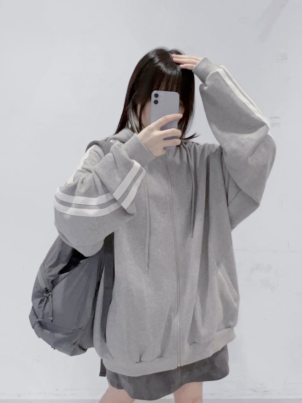 グレー系のバックパック/リュック、グレー系のパーカー、ブラック系のスカートを着用したレディースの秋コーディネートの4枚目の写真