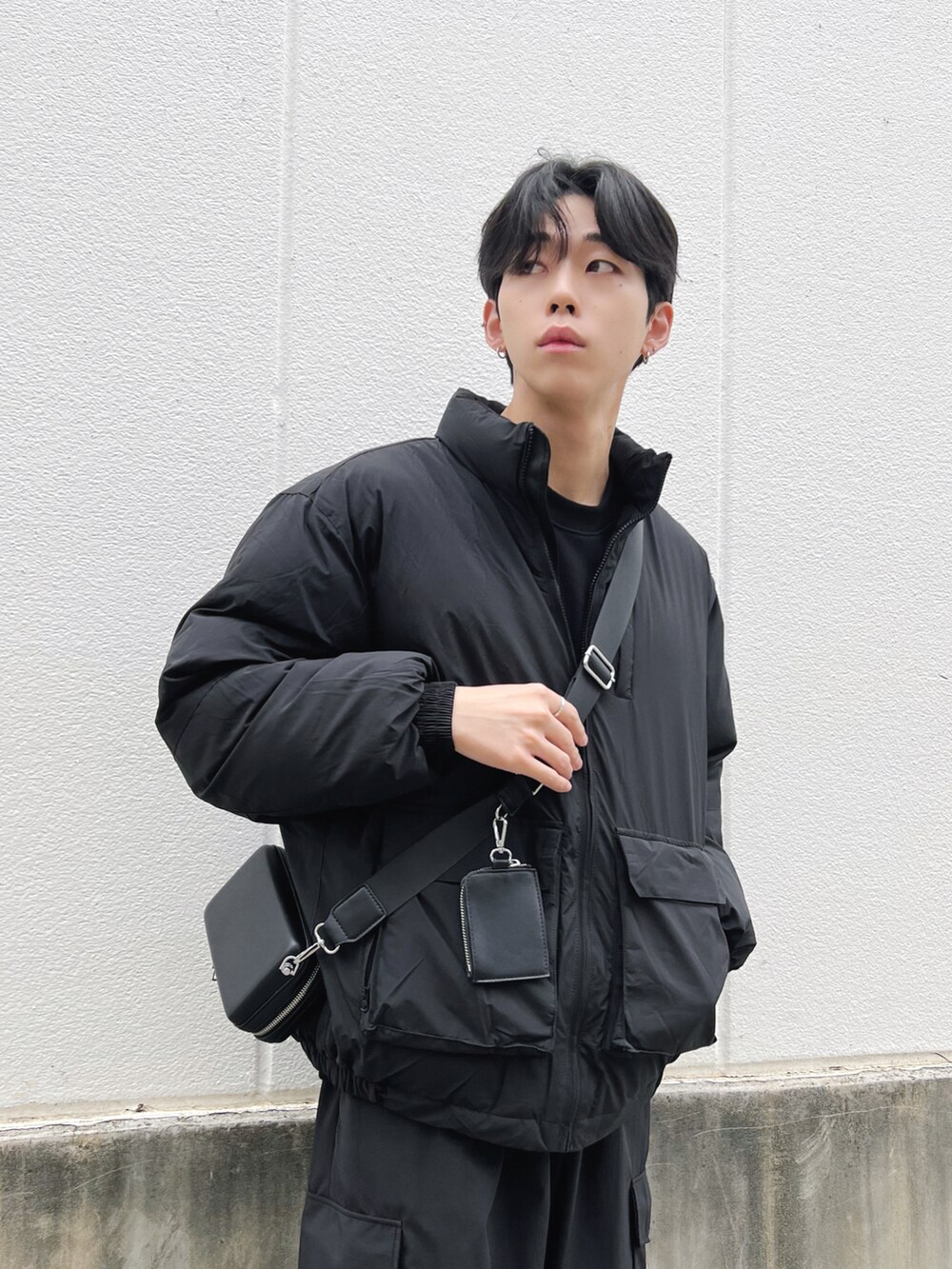 ブラック系のスニーカー、ブラック系のカーゴパンツ、ブラック系のダウンジャケット/コートを着用したメンズの冬コーディネートの2枚目の写真