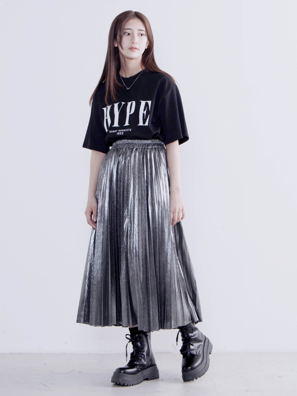 ブラック系のTシャツ/カットソー、シルバー系のスカート、ブラック系のブーツを着用したレディースの夏コーディネートの2枚目の写真