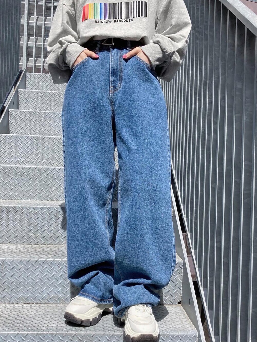 ブルー系のデニムパンツ、グレー系のスウェット、シルバー系のネックレスを着用したレディースの春コーディネートの3枚目の写真