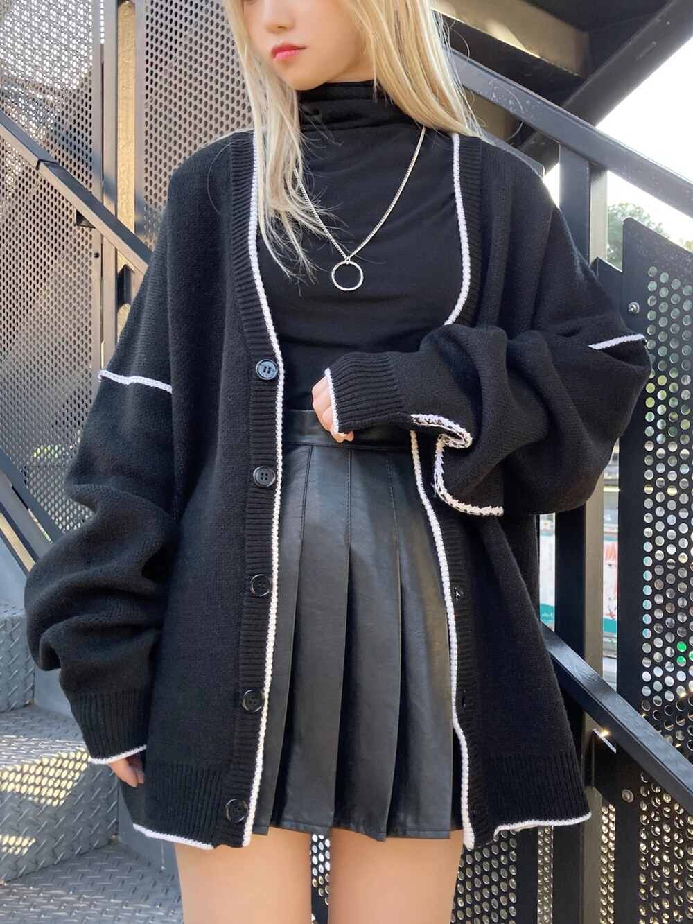 ブラック系のブーツ、ブラック系のカーディガン/ボレロ、ブラック系のTシャツ/カットソーを着用したレディースの冬コーディネートの2枚目の写真