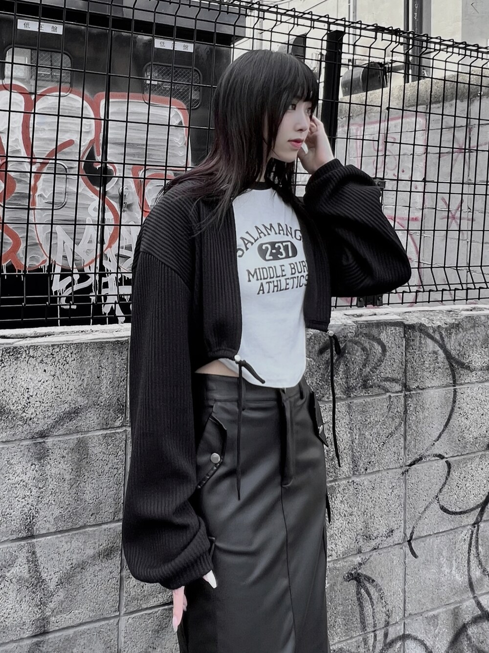 ブラック系のブーツ、ブラック系のスカート、ブラック系のTシャツ/カットソーを着用したレディースの秋コーディネートの2枚目の写真