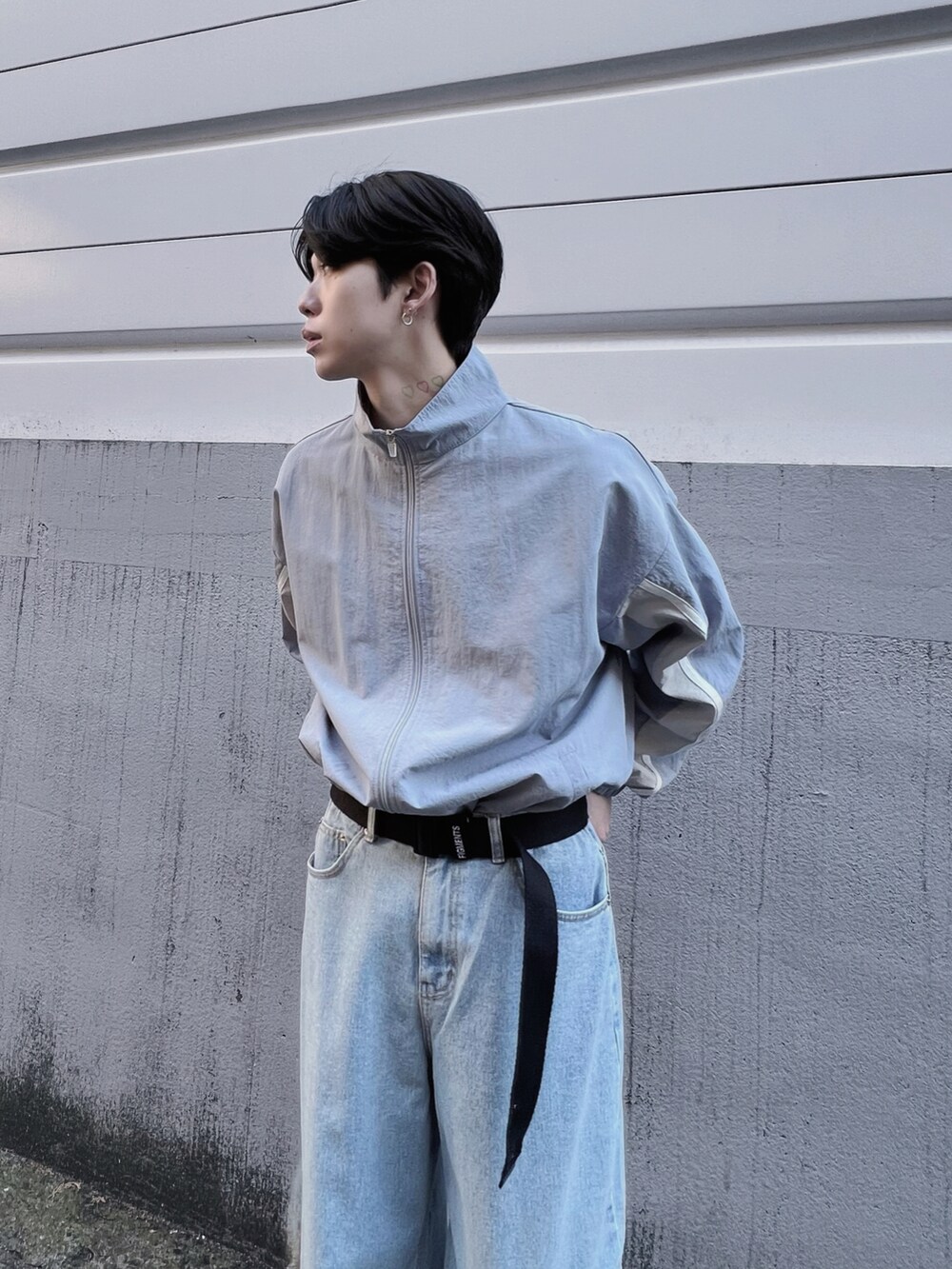 ブルー系のナイロンジャケット、ブルー系のデニムパンツ、ホワイト系のスニーカーを着用したメンズの春コーディネートの2枚目の写真