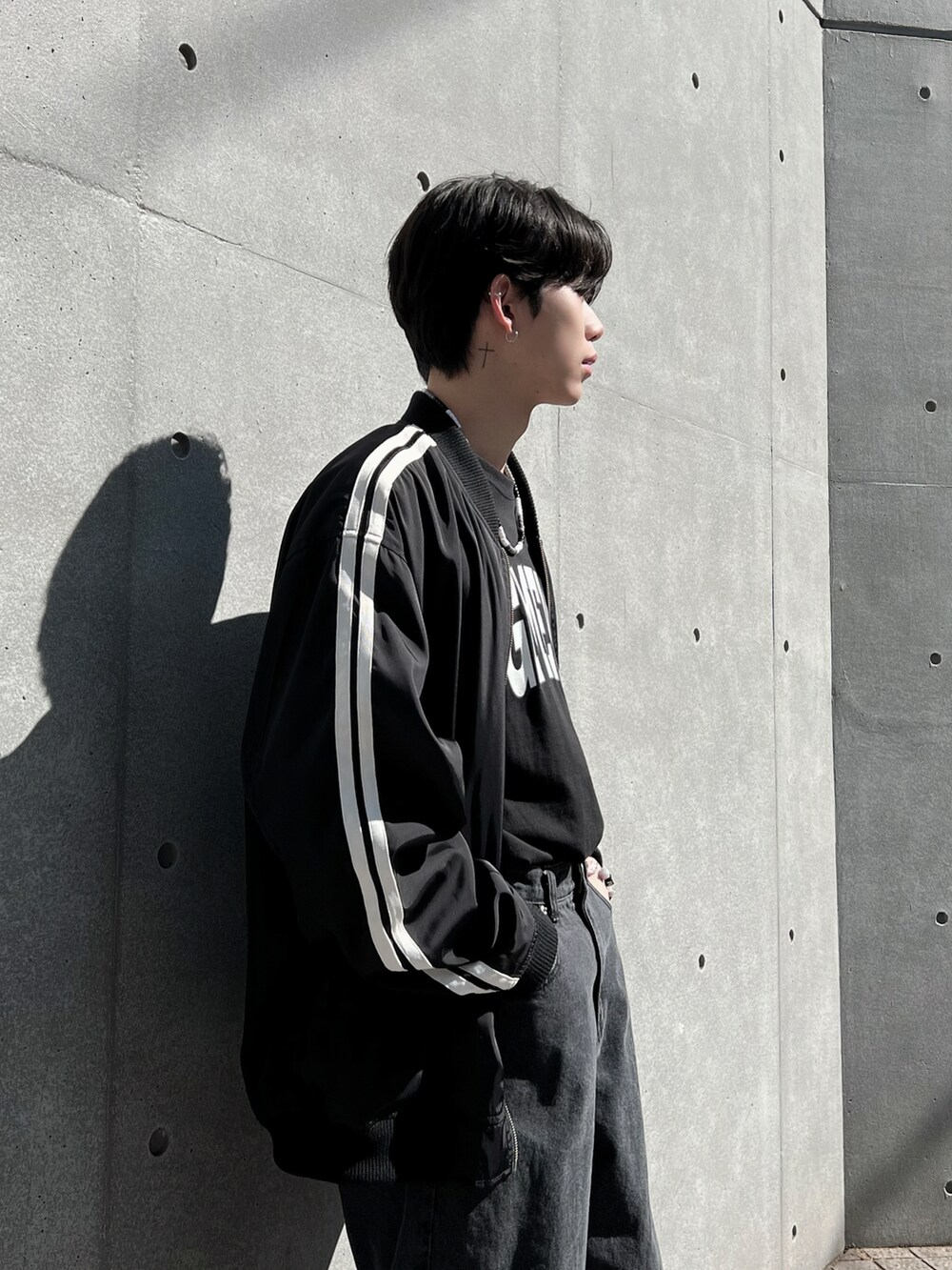 ブラック系のデニムパンツ、ブラック系のTシャツ/カットソー、ブラック系のブルゾンを着用したメンズの春コーディネートの3枚目の写真