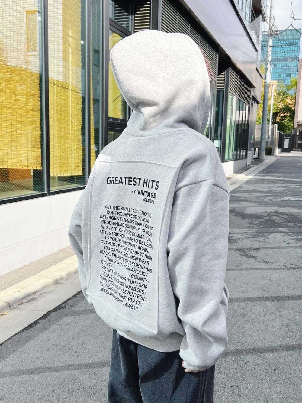 ブラック系のデニムパンツ、ホワイト系のTシャツ/カットソー、グレー系のパーカーを着用したレディースの冬コーディネートの4枚目の写真