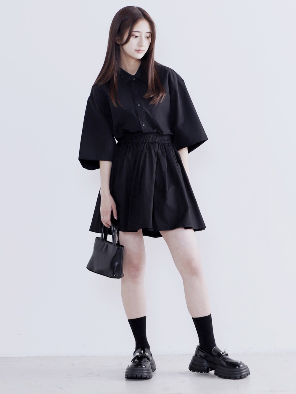 ブラック系のドレスシューズ、ブラック系のショルダーバッグ、ブラック系のシャツ/ブラウスを着用したレディースの春コーディネートの3枚目の写真