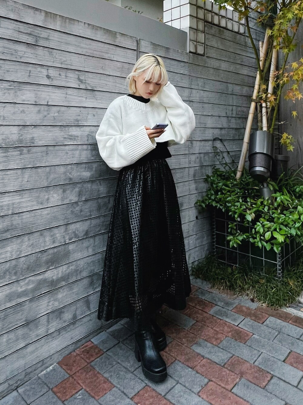 ホワイト系のニット/セーター、ブラック系のTシャツ/カットソー、ブラック系のブーツを着用したレディースの冬コーディネートの2枚目の写真