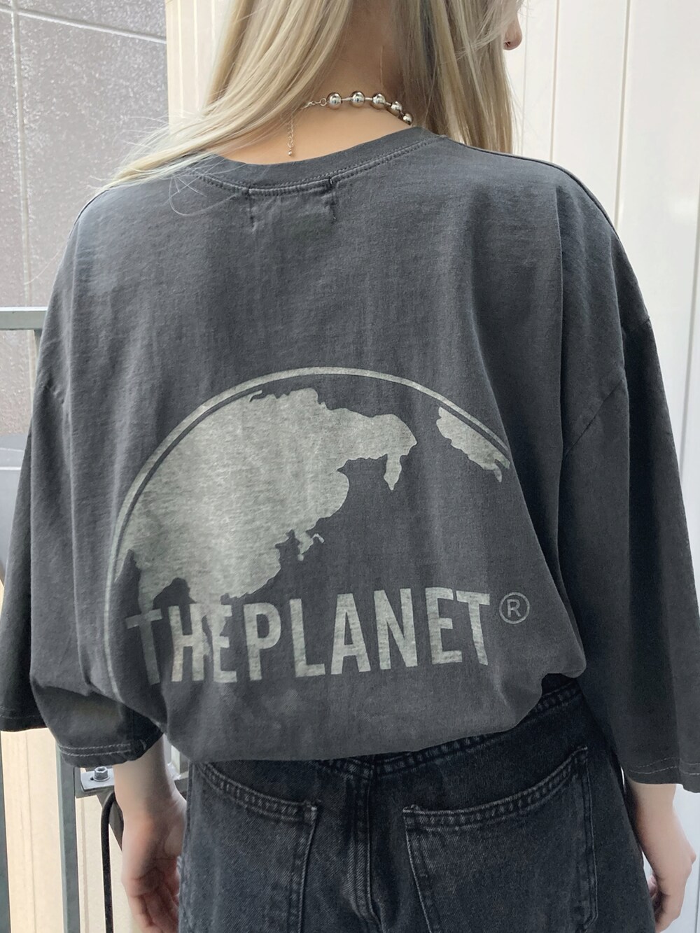ブラック系のデニムパンツ、ブラック系のスニーカー、ブラック系のTシャツ/カットソーを着用したレディースの春コーディネートの2枚目の写真