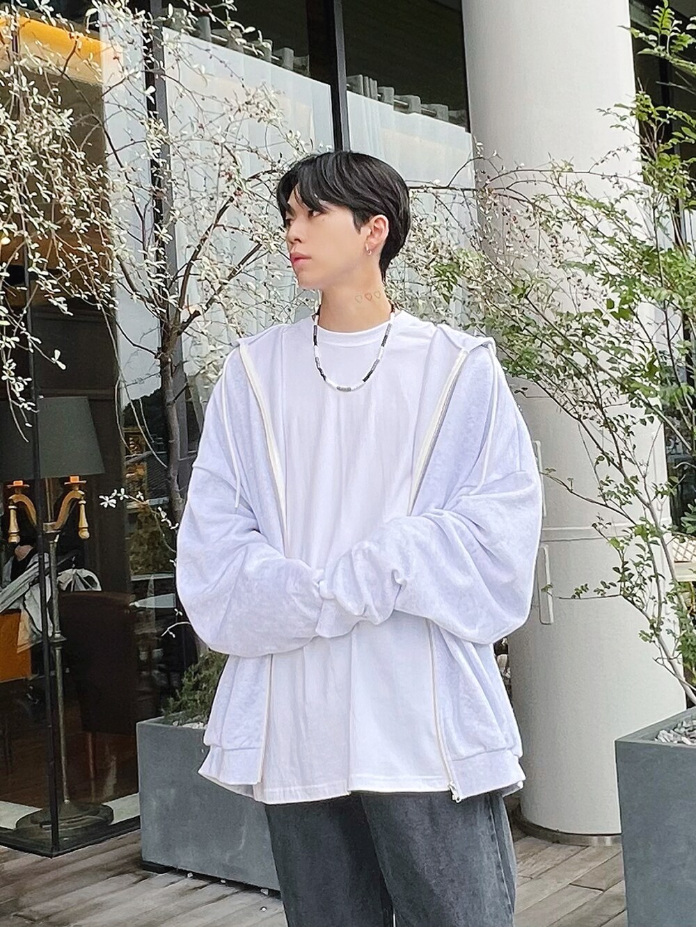 グレー系のパーカー、ブラック系のデニムパンツ、ブラック系のスニーカーを着用したメンズの冬コーディネートの2枚目の写真