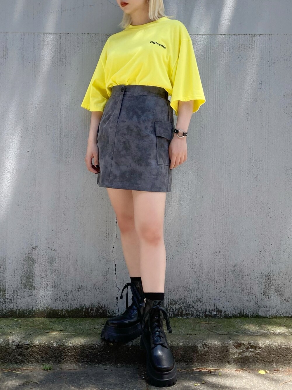ブラック系のスカート、ブラック系のブーツ、イエロー系のTシャツ/カットソーを着用したレディースの夏コーディネートの2枚目の写真