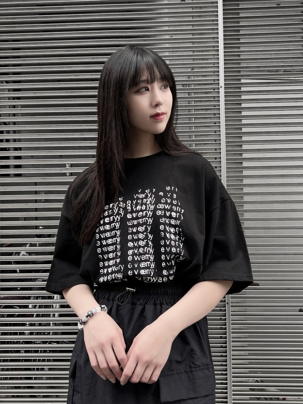 ブラック系のサンダル、ブラック系のスカート、ブラック系のTシャツ/カットソーを着用したレディースの夏コーディネートの2枚目の写真