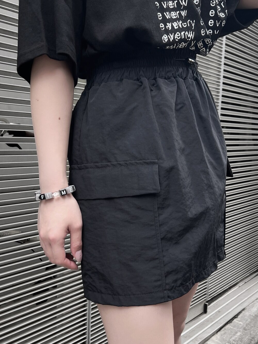 ブラック系のサンダル、ブラック系のスカート、ブラック系のTシャツ/カットソーを着用したレディースの夏コーディネートの4枚目の写真