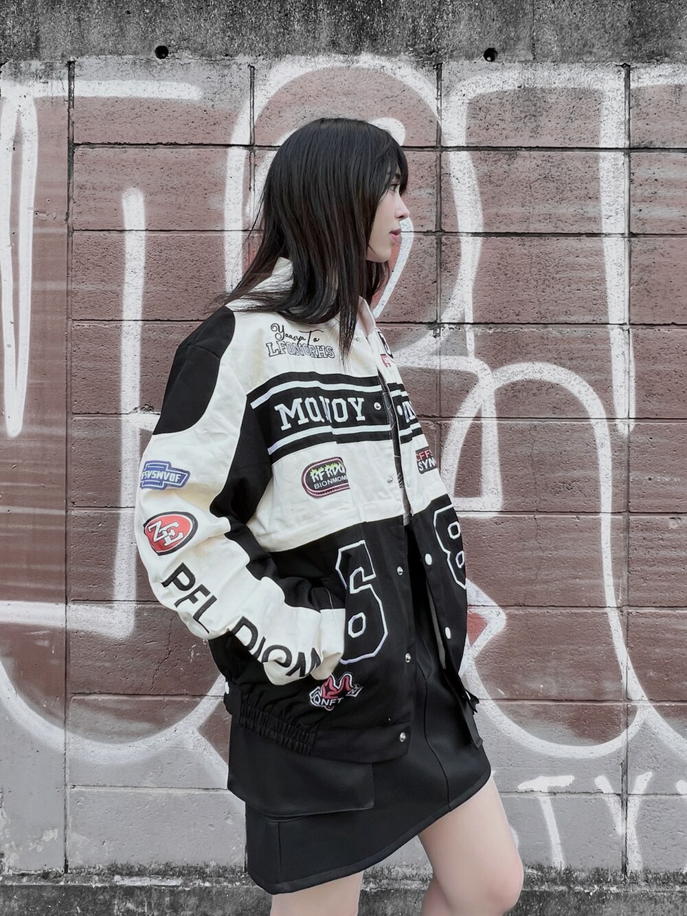ホワイト系のTシャツ/カットソー、ブラック系のブーツ、ブラック系のブルゾンを着用したレディースの秋コーディネートの4枚目の写真