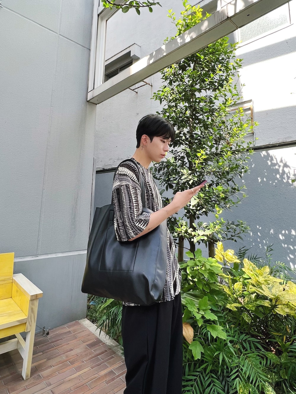 その他のTシャツ/カットソー、ブラック系のトートバッグ、ブラック系のスラックスを着用したメンズの秋コーディネートの2枚目の写真