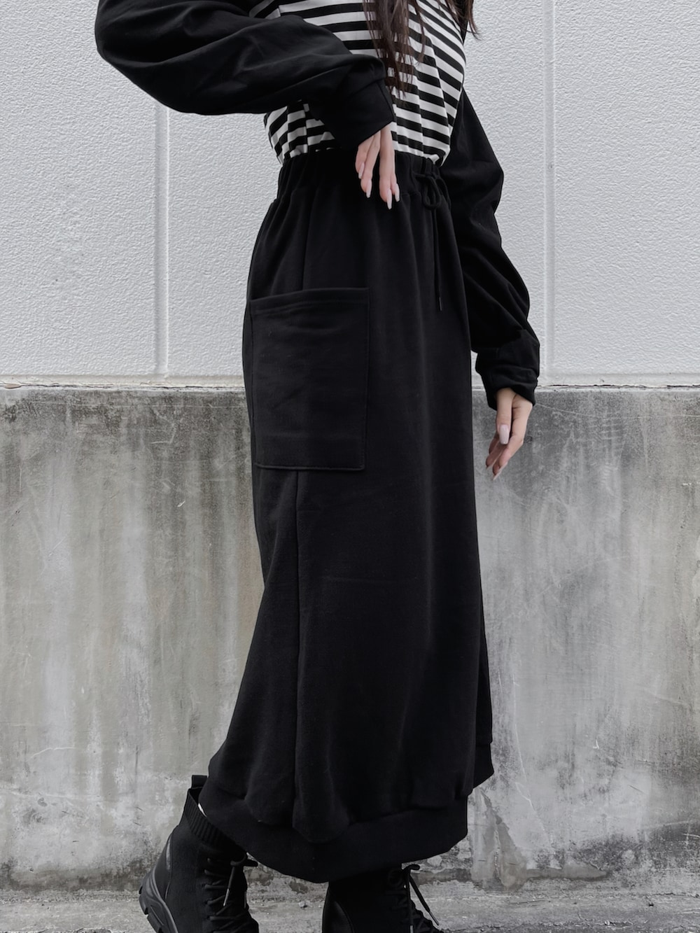 ブラック系のスカート、ブラック系のブーツ、ブラック系のカーディガン/ボレロを着用したレディースの春コーディネートの4枚目の写真