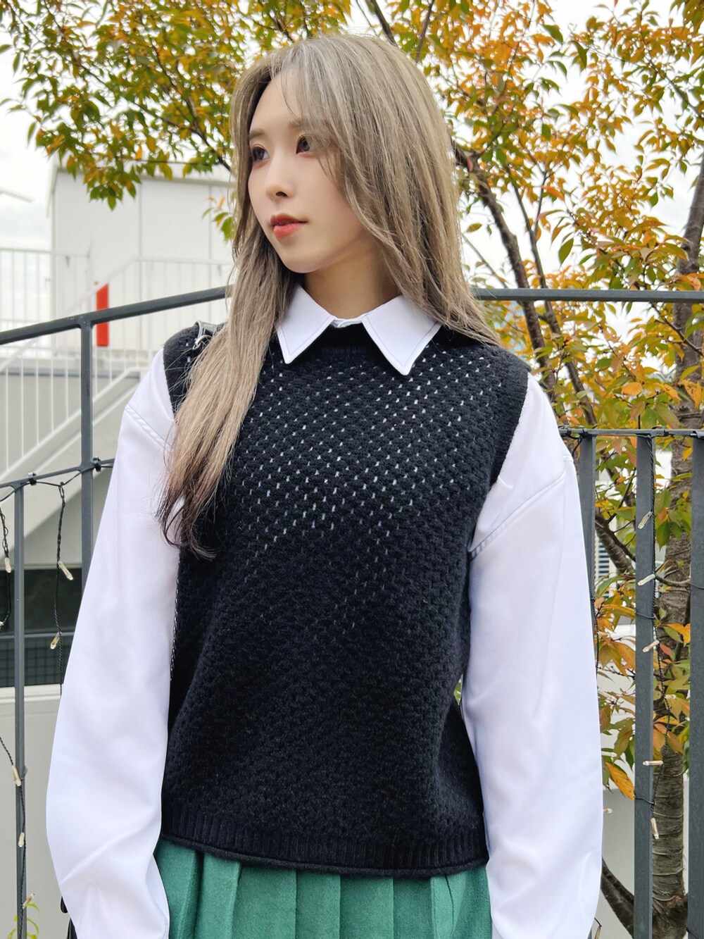 ブラック系のドレスシューズ、グリーン系のスカート、ブラック系のベストを着用したレディースの冬コーディネートの3枚目の写真