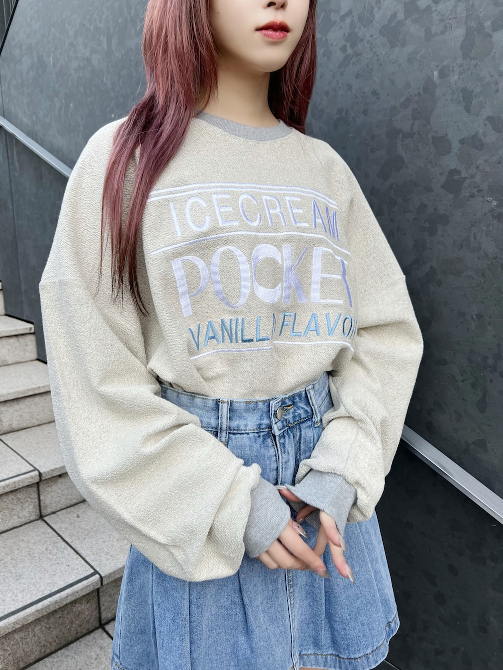 グリーン系のダウンベスト、グレー系のスウェット、ブルー系のデニムスカートを着用したレディースの冬コーディネートの5枚目の写真