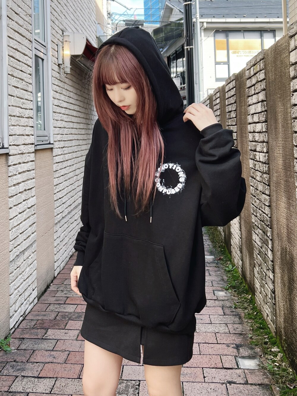 ブラック系のその他シューズ、ブラック系のパーカー、ブラック系のスカートを着用したレディースの冬コーディネートの3枚目の写真