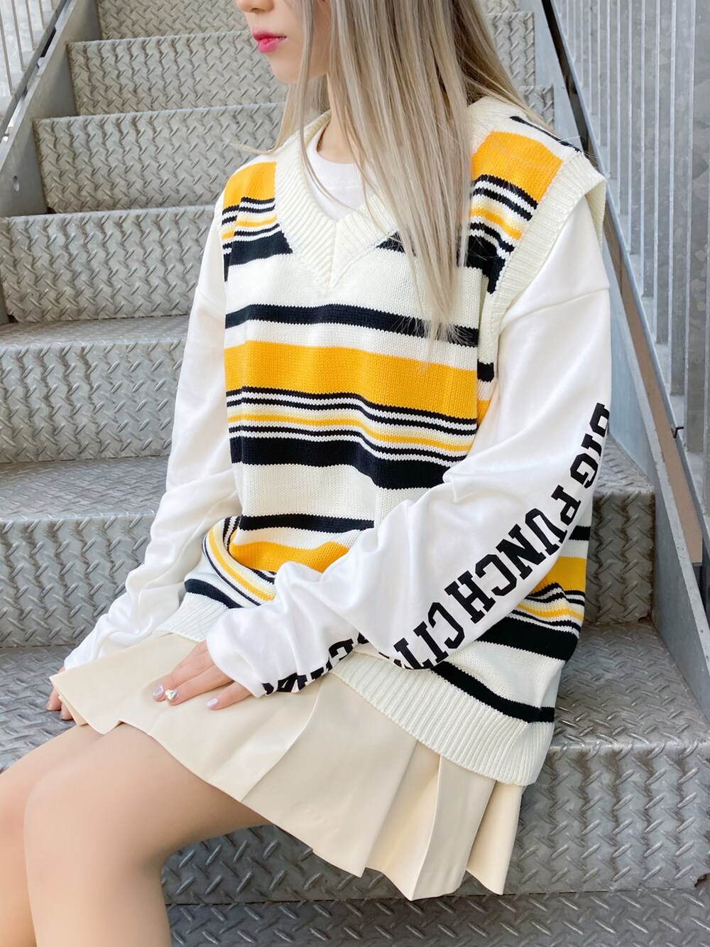 ホワイト系のスカート、ホワイト系のスニーカー、ブラック系のスタジャンを着用したレディースの冬コーディネートの3枚目の写真