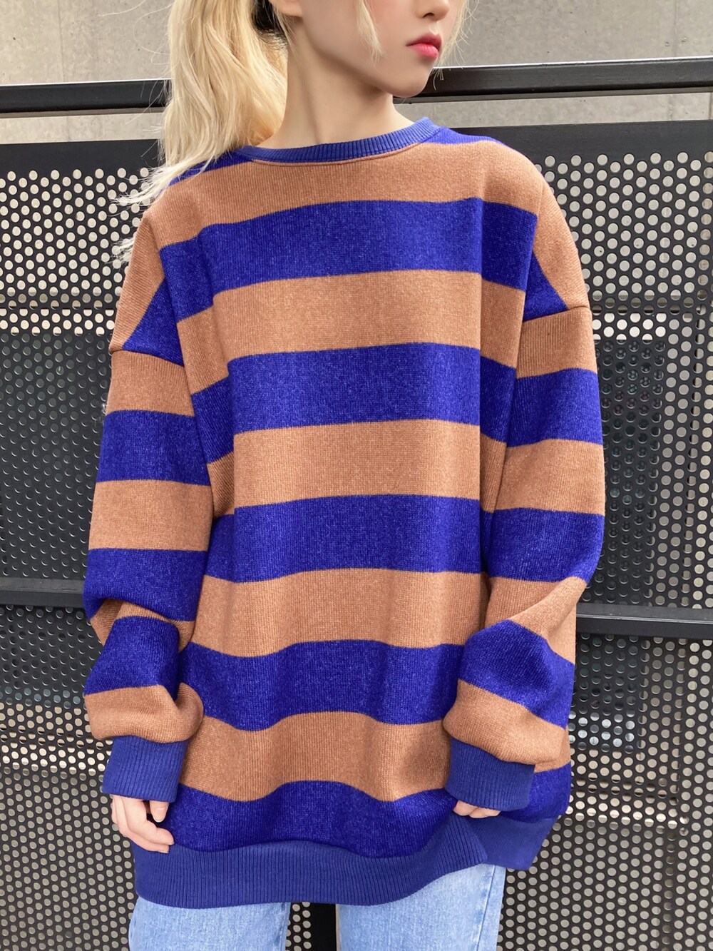 ブルー系のニット/セーター、ブルー系のデニムパンツ、ホワイト系のスニーカーを着用したレディースの秋コーディネートの2枚目の写真