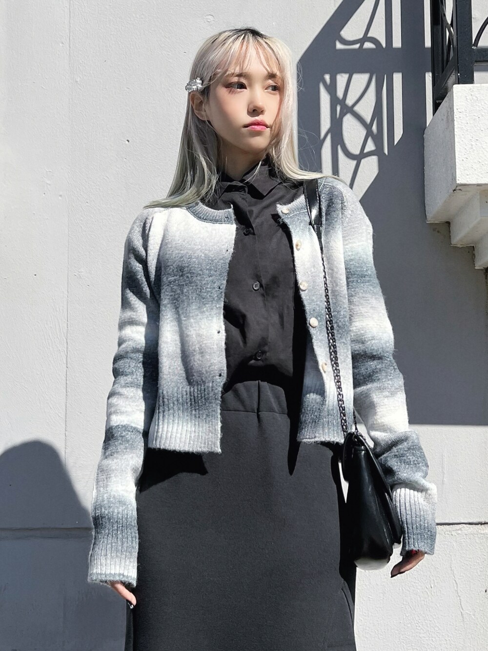 ホワイト系のシャツ/ブラウス、ブラック系のカーディガン/ボレロ、ブラック系のショルダーバッグを着用したレディースの冬コーディネートの2枚目の写真
