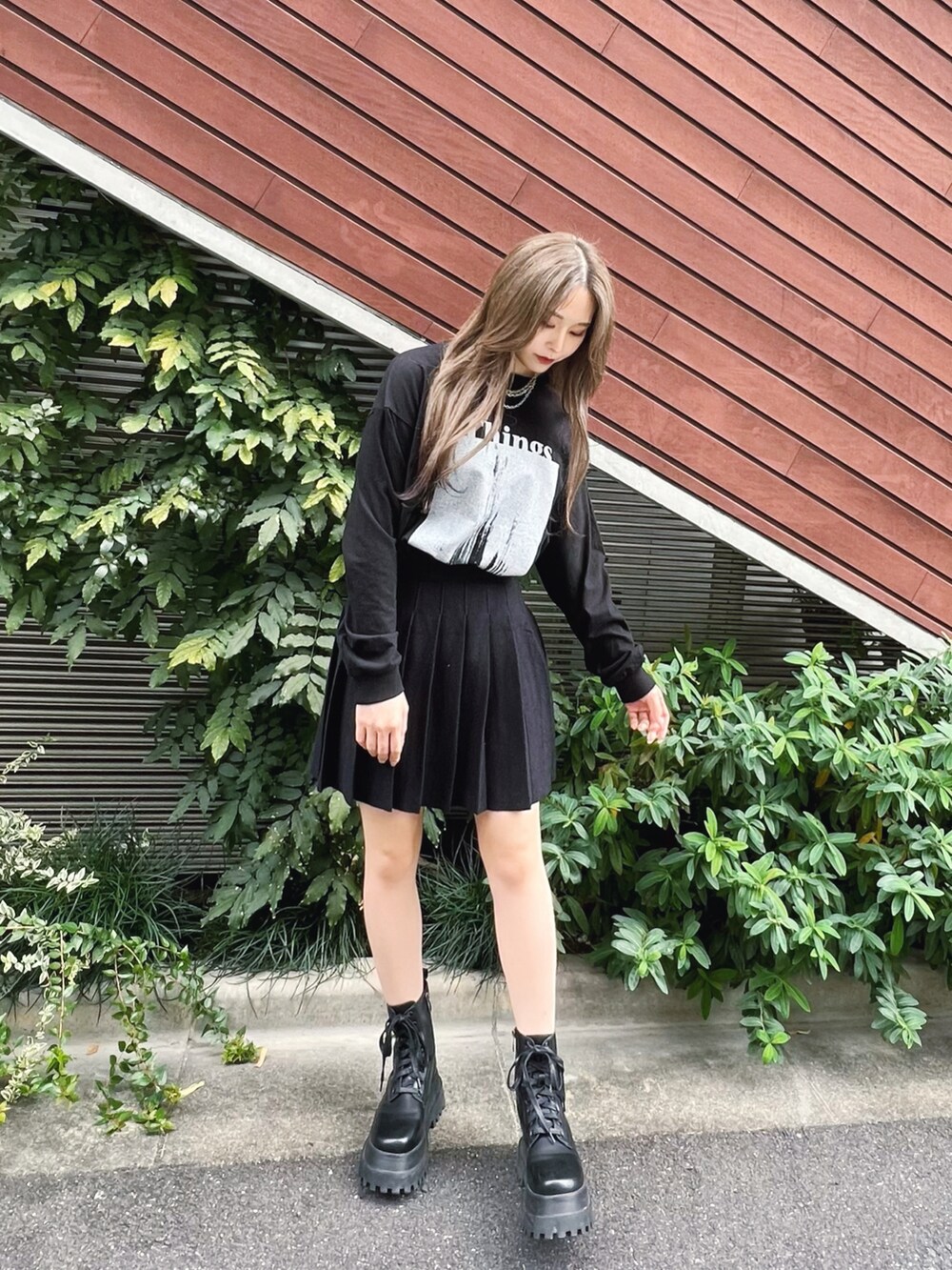 ブルー系のカバーオール、ブラック系のTシャツ/カットソー、ブラック系のスカートを着用したレディースの冬コーディネートの3枚目の写真