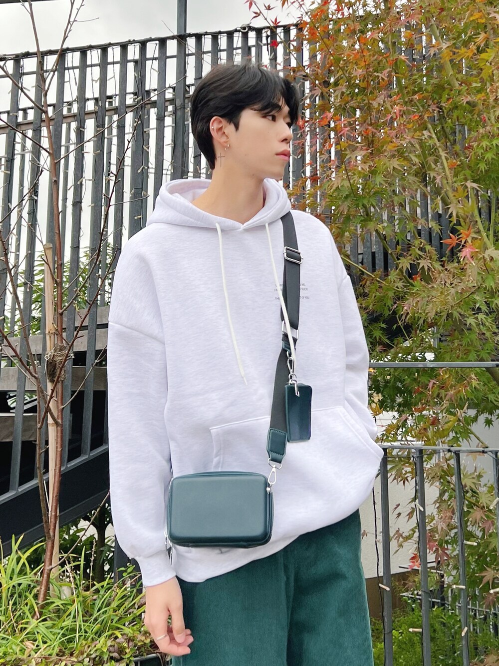 グレー系のパーカー、グリーン系のその他パンツ、ホワイト系のスニーカーを着用したメンズの冬コーディネートの3枚目の写真