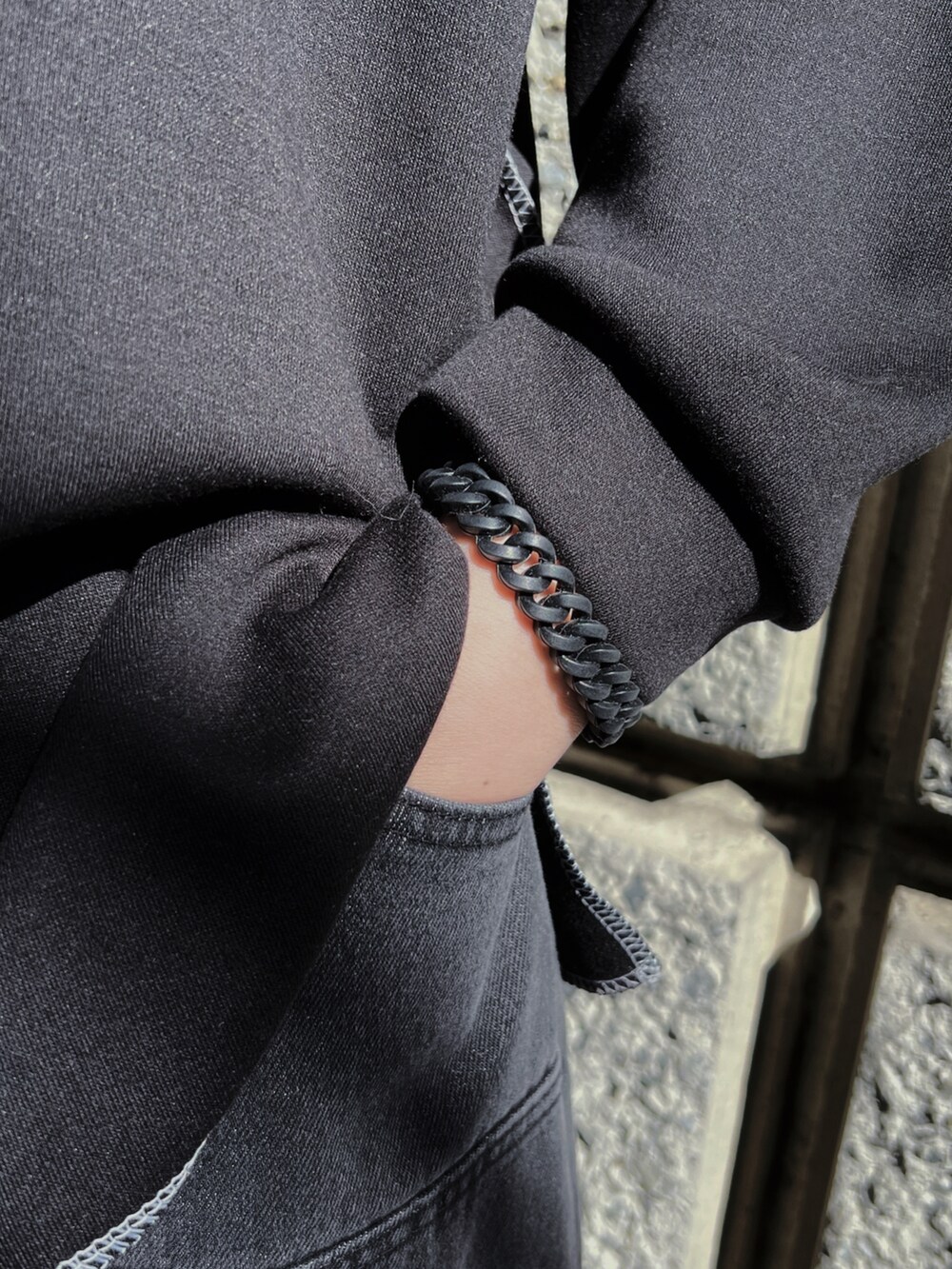 ブラック系のTシャツ/カットソー、ブラック系のスニーカー、ブラック系のデニムパンツを着用したメンズの春コーディネートの4枚目の写真