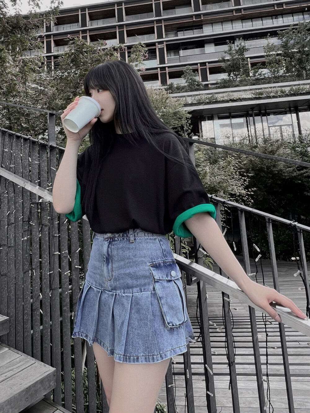 グリーン系のTシャツ/カットソー、ブルー系のデニムスカートを着用したレディースの夏コーディネートの2枚目の写真