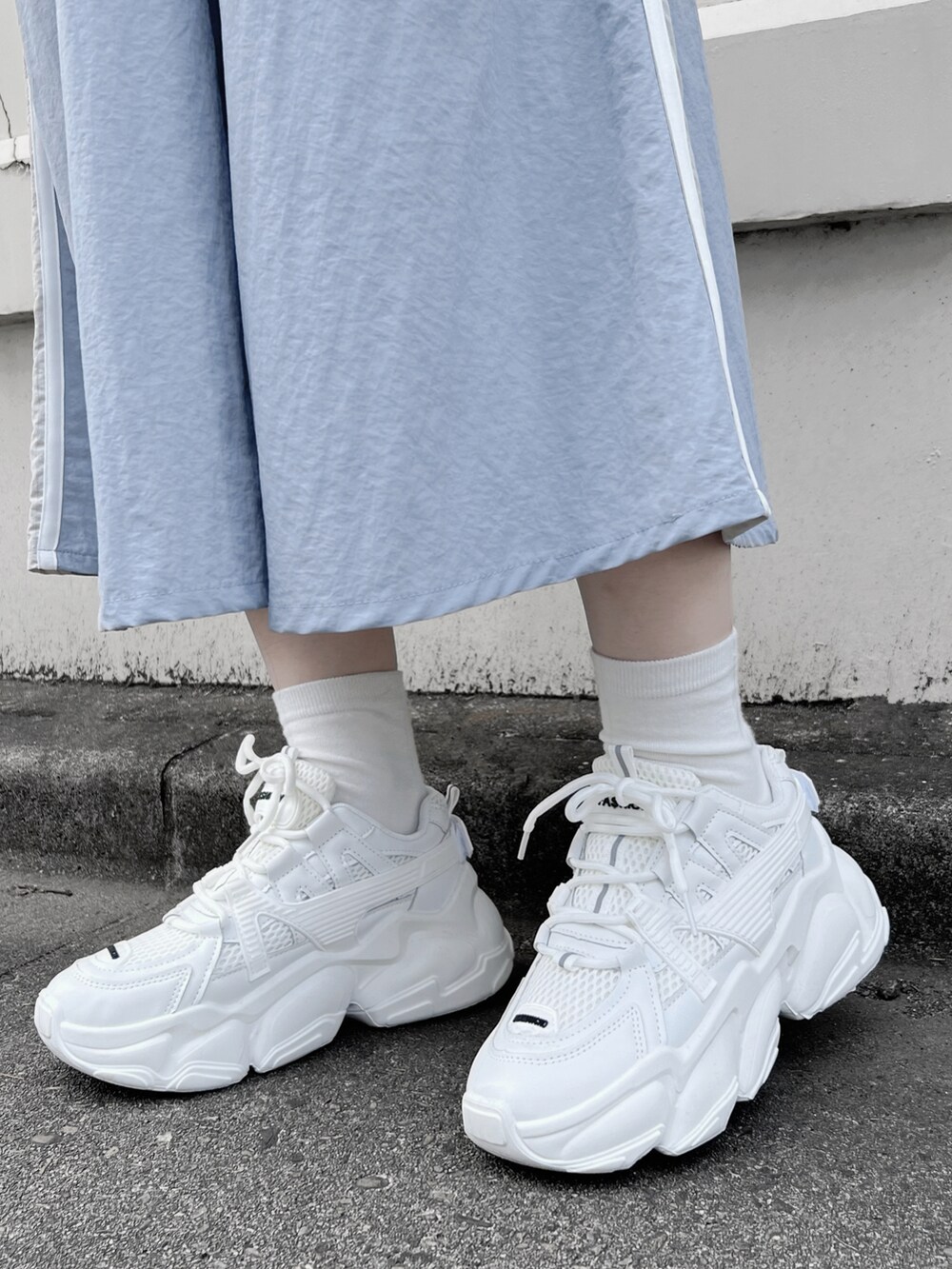 ホワイト系のTシャツ/カットソー、ブルー系のスカート、ホワイト系のスニーカーを着用したレディースの春コーディネートの4枚目の写真